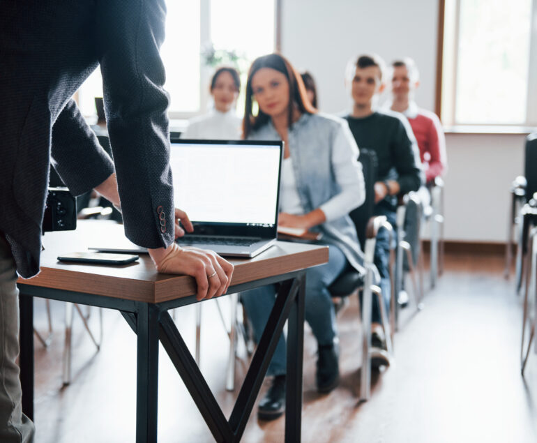 Un formateur animant une session de formation dans une salle, symbolisant l'accompagnement professionnel des apprenants.